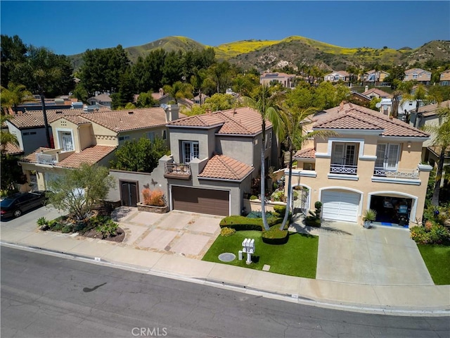 mediterranean / spanish-style house with a balcony, driveway, french doors, and a mountain view