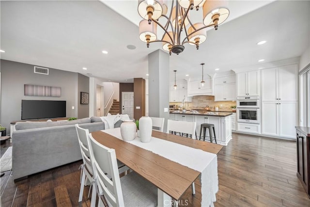 dining room featuring recessed lighting, stairway, dark wood-style floors, and a chandelier