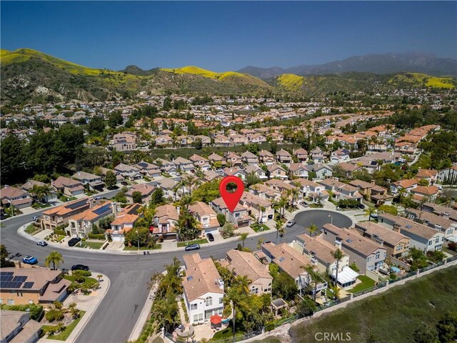 aerial view of property's location featuring nearby suburban area and a mountainous background