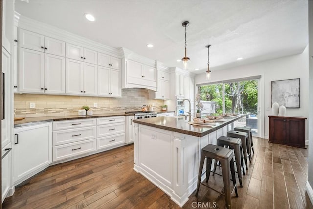 kitchen with dark countertops, dark wood-style flooring, white cabinets, and recessed lighting