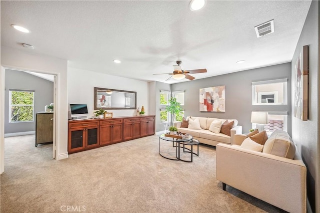 living room with light carpet, a ceiling fan, recessed lighting, baseboards, and a textured ceiling