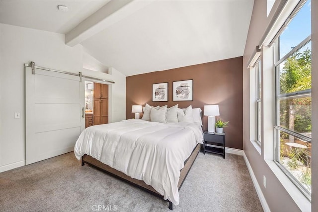 bedroom with a barn door, carpet, baseboards, and ensuite bath