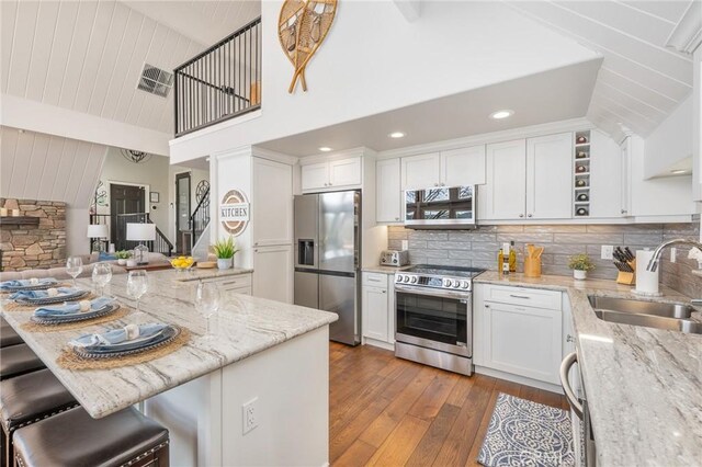 27550 N Bay Rd, Lake Arrowhead, CA 92352 - kitchen with a sink, stainless steel appliances, dark wood-style floors, white cabinets, and light stone countertops