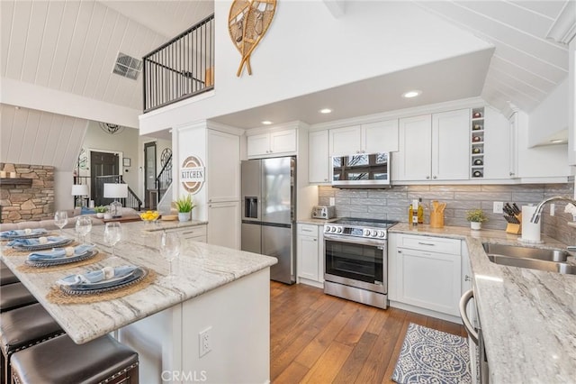 27550 N Bay Rd, Lake Arrowhead, CA 92352 - kitchen with stainless steel appliances, a sink, dark wood-style floors, white cabinets, and light stone countertops