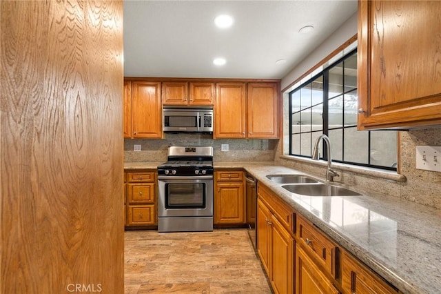 kitchen featuring brown cabinets, stainless steel appliances, and a sink
