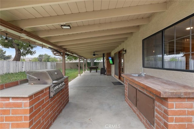 view of patio featuring area for grilling, fence, a sink, and a grill