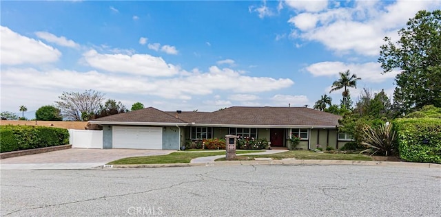 single story home featuring fence, an attached garage, driveway, and stucco siding