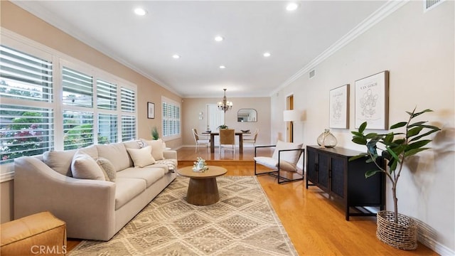 living area with crown molding, light wood-style floors, a chandelier, recessed lighting, and visible vents