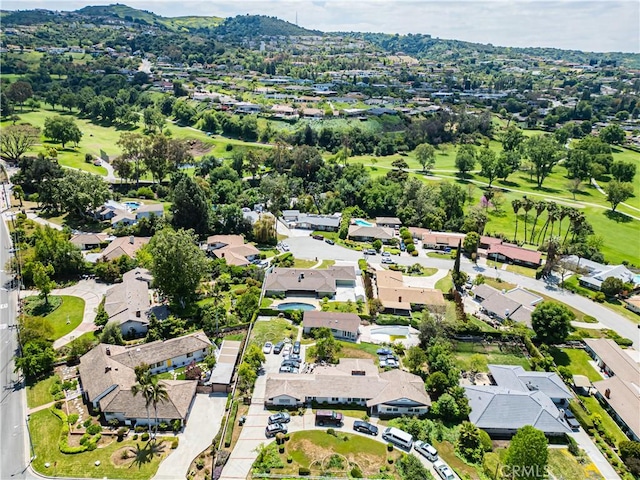 drone / aerial view with a residential view, a mountain view, and view of golf course