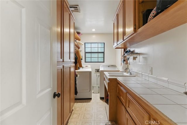 laundry room with cabinet space, recessed lighting, light floors, visible vents, and washing machine and dryer
