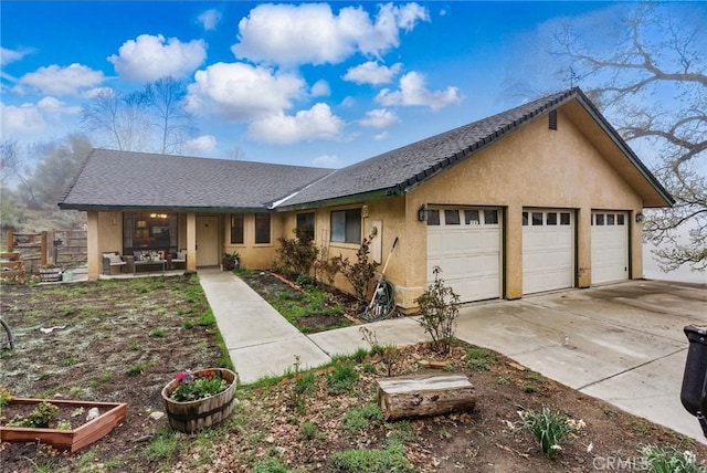 view of front of home featuring fence, a garage, driveway, and stucco siding