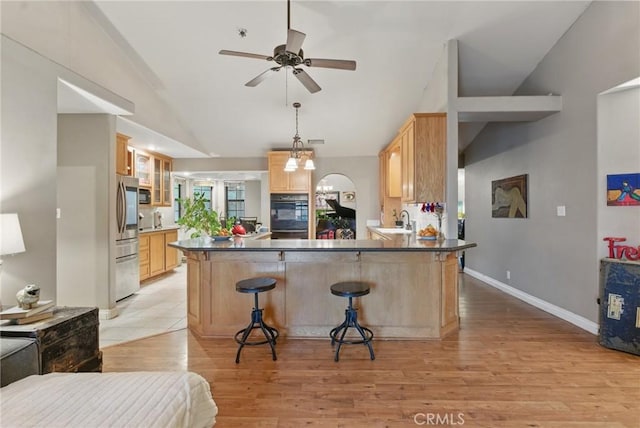 kitchen featuring light brown cabinetry, a sink, smart refrigerator, a peninsula, and vaulted ceiling