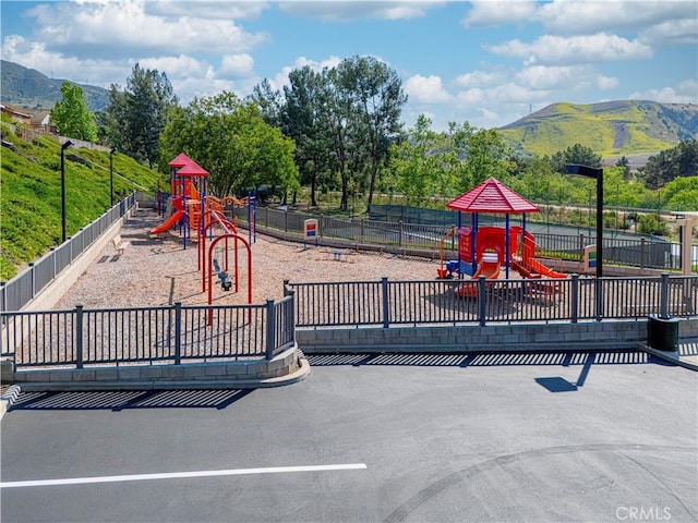 community jungle gym with fence and a mountain view