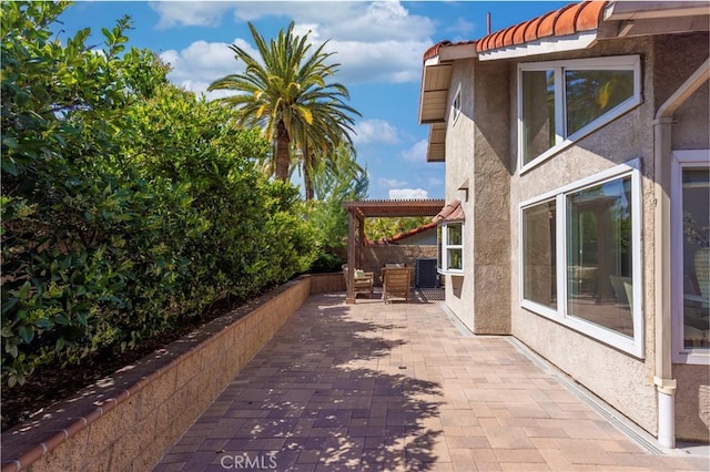 view of property exterior featuring a patio, stucco siding, and a tiled roof