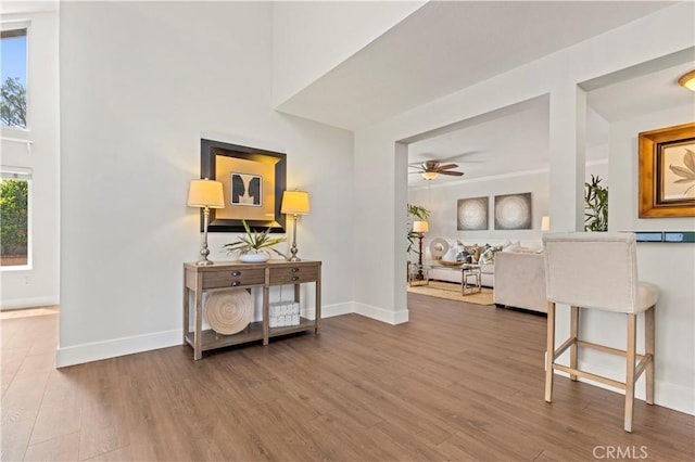 corridor featuring baseboards and wood finished floors