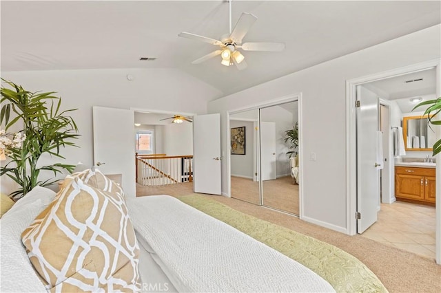 bedroom with visible vents, vaulted ceiling, a sink, a closet, and light carpet