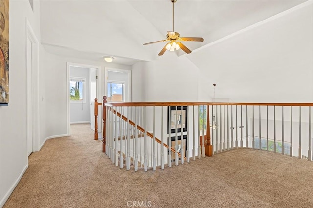 hallway with baseboards, carpet flooring, and vaulted ceiling