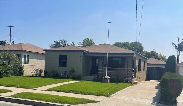 bungalow-style house with a front lawn, stucco siding, and fence