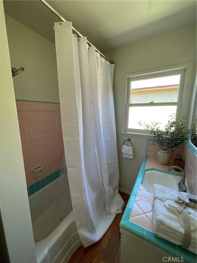 full bath featuring a sink, wood finished floors, and shower / bath combination with curtain