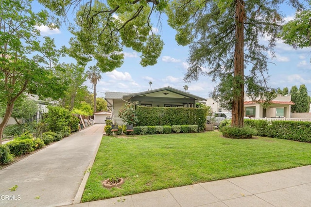 view of front of home featuring fence, driveway, and a front yard