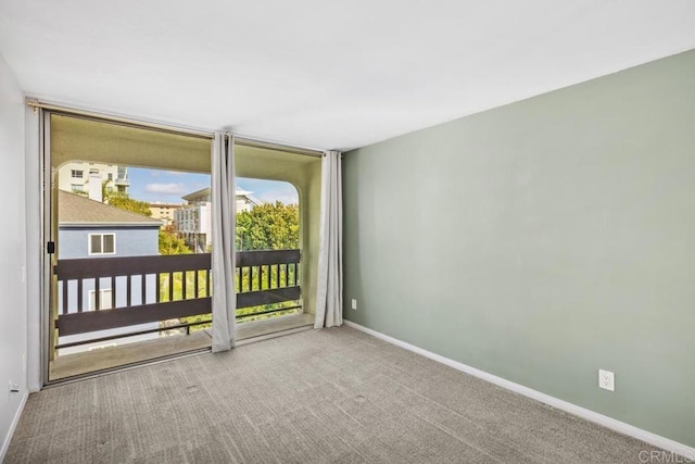 carpeted spare room with baseboards