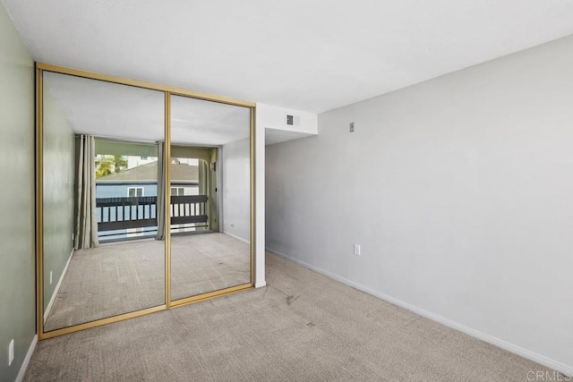 unfurnished bedroom with carpet floors, baseboards, visible vents, and a closet