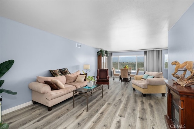 1530 Greenbriar Ave, Corona, CA 92878 - living area with visible vents, light wood-style flooring, and baseboards