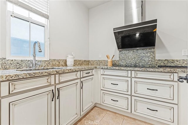 kitchen with light tile patterned floors, light stone counters, and a sink