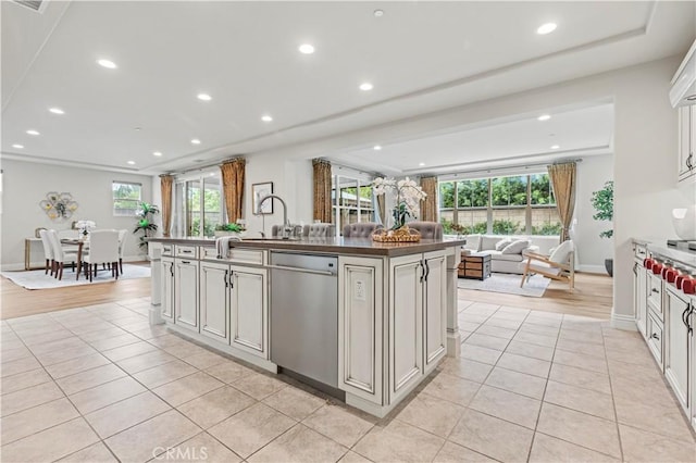 kitchen with light tile patterned flooring, open floor plan, a healthy amount of sunlight, and dishwasher
