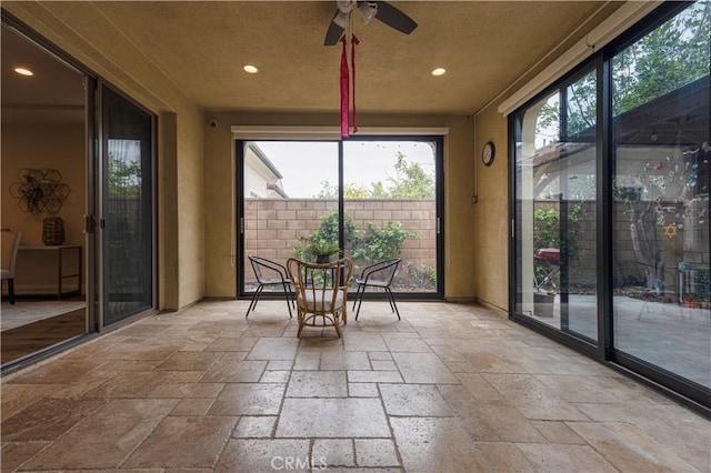 sunroom featuring a healthy amount of sunlight, recessed lighting, and stone tile floors