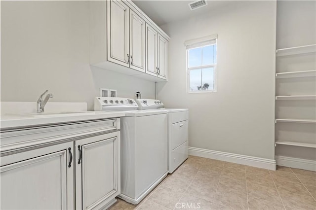 clothes washing area featuring cabinet space, washing machine and clothes dryer, a sink, baseboards, and visible vents