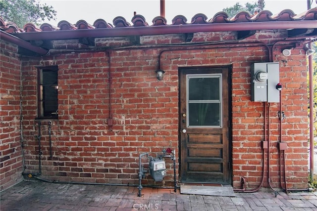 entrance to property featuring brick siding