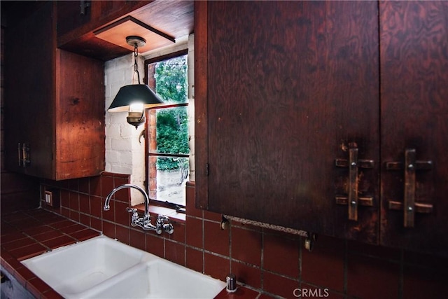 details featuring tile countertops, decorative backsplash, and a sink