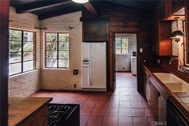 kitchen featuring tile countertops, a sink, lofted ceiling with beams, white fridge with ice dispenser, and black dishwasher