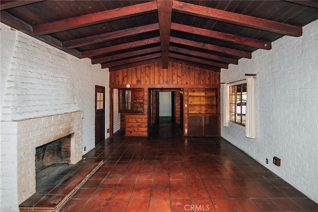unfurnished living room with wood ceiling, brick wall, a fireplace, tile patterned floors, and vaulted ceiling with beams