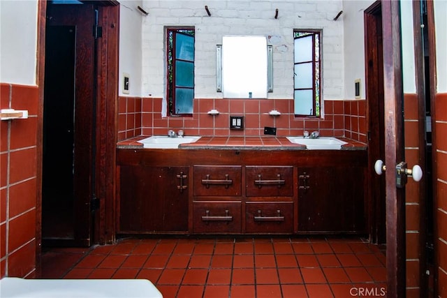 bathroom featuring a sink, tile patterned floors, a wainscoted wall, and double vanity