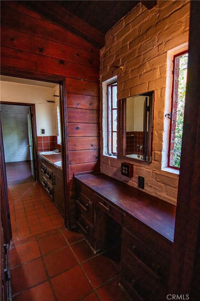 bathroom featuring wooden walls, tile patterned floors, lofted ceiling with beams, and wood ceiling