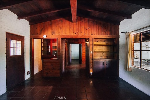 hall featuring wooden walls, wood ceiling, plenty of natural light, and vaulted ceiling with beams