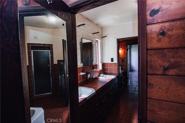 full bathroom featuring double vanity, a sink, walk in shower, and tile patterned floors