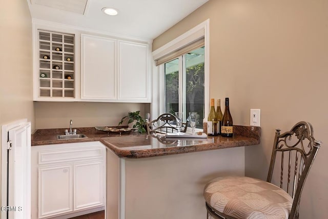 bar featuring a sink, indoor wet bar, and recessed lighting