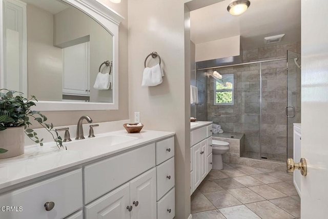 full bathroom with vanity, a shower stall, toilet, and visible vents