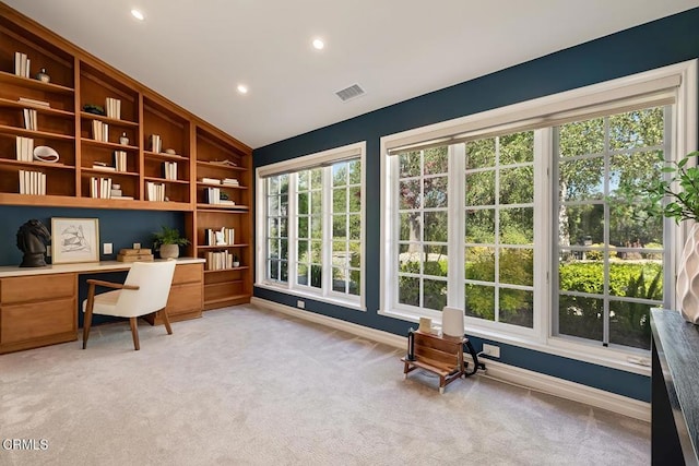 home office featuring baseboards, visible vents, lofted ceiling, and light colored carpet