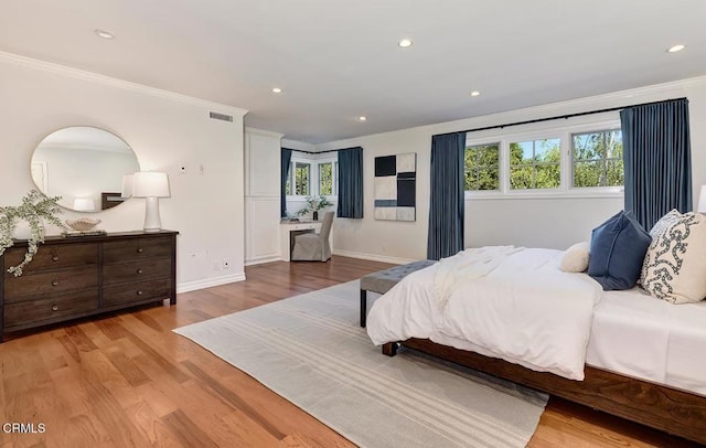 bedroom with recessed lighting, ornamental molding, baseboards, and wood finished floors