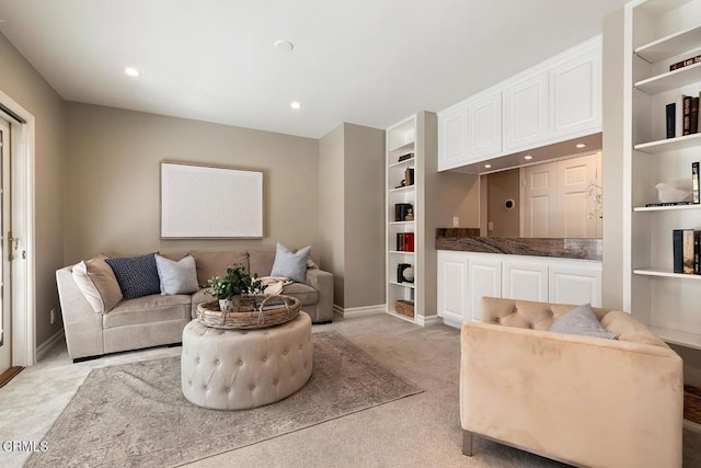 living room featuring recessed lighting, baseboards, light colored carpet, and built in features
