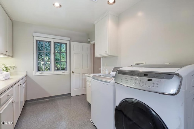 laundry area featuring cabinet space, washing machine and clothes dryer, a sink, recessed lighting, and baseboards