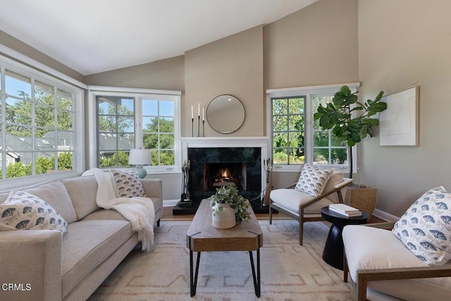 living room featuring a premium fireplace, baseboards, and a healthy amount of sunlight