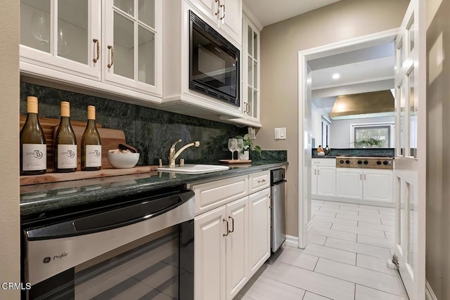 kitchen featuring wine cooler, black microwave, dark countertops, a sink, and light tile patterned floors