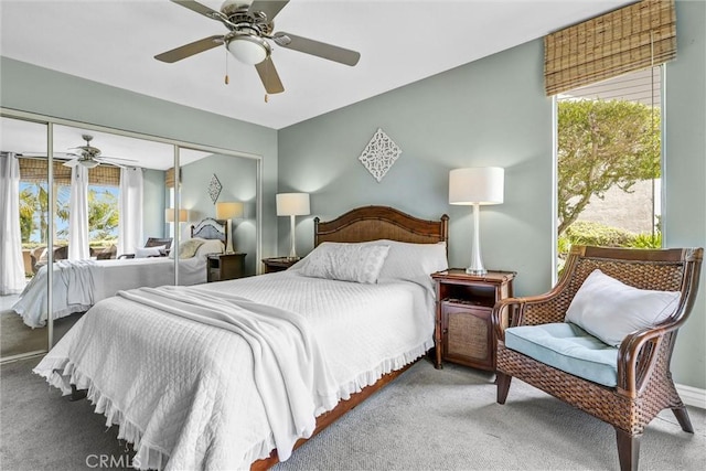 carpeted bedroom with multiple windows, a ceiling fan, and a closet