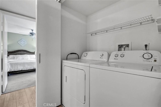 laundry room featuring separate washer and dryer, laundry area, light wood finished floors, and ceiling fan