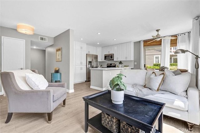 living room with visible vents, baseboards, recessed lighting, a ceiling fan, and light wood-style flooring